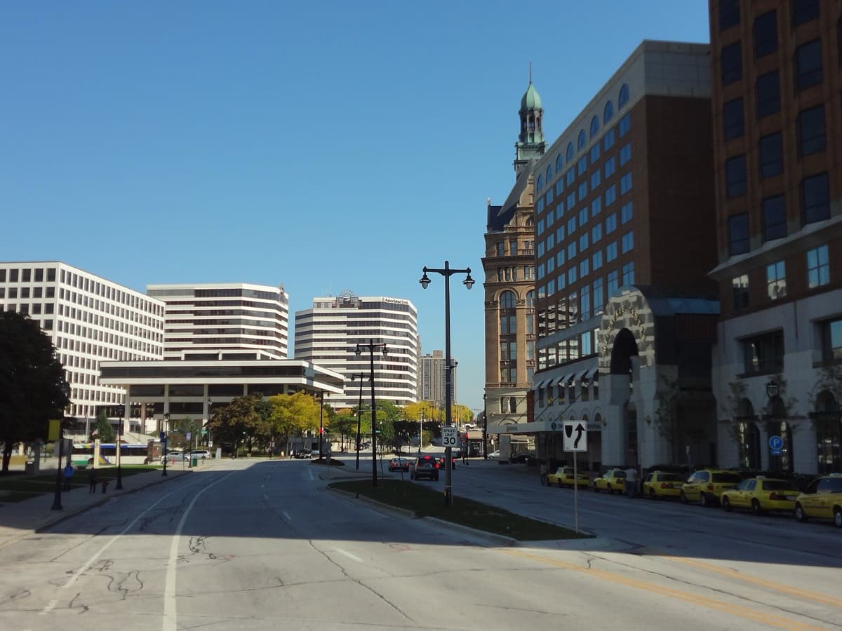 A downtown Milwaukee street with the Milwaukee City Hall tower